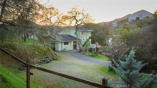 view of front of house with gravel driveway and fence