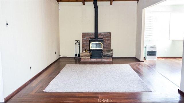 living room featuring a wood stove, baseboards, and dark wood-style flooring