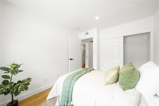 bedroom featuring recessed lighting, visible vents, baseboards, light wood-style floors, and a closet