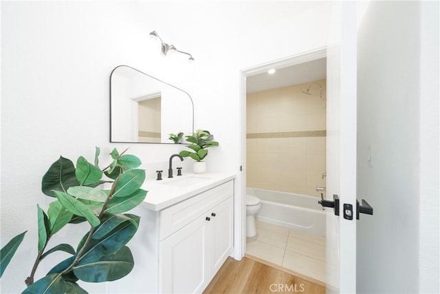 full bath featuring toilet, bathtub / shower combination, wood finished floors, and vanity