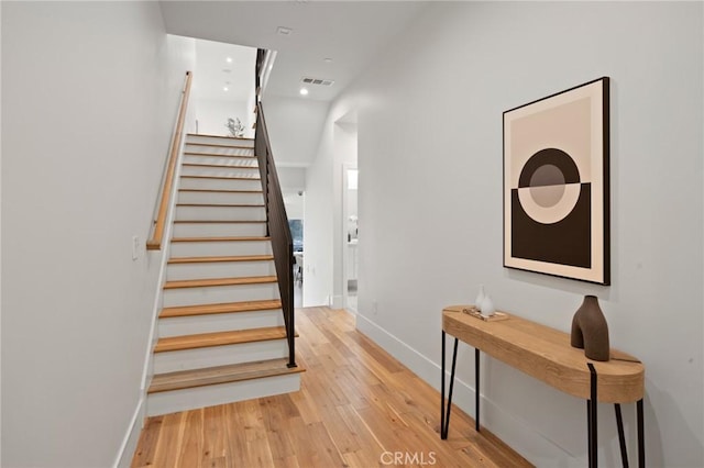 stairs featuring baseboards, visible vents, wood finished floors, and recessed lighting