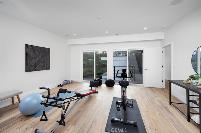 exercise area featuring light wood finished floors, visible vents, baseboards, and recessed lighting