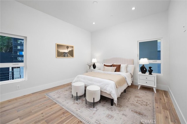 bedroom with baseboards, wood finished floors, and recessed lighting