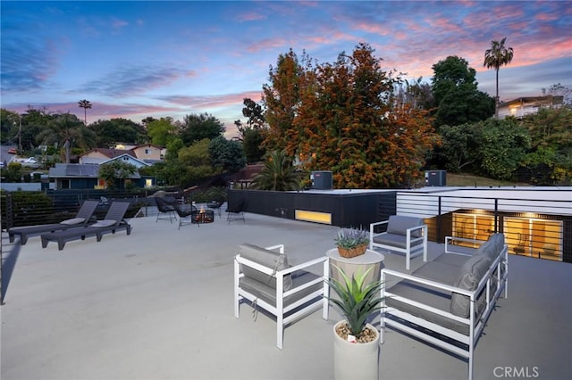 patio terrace at dusk featuring central air condition unit and an outdoor hangout area