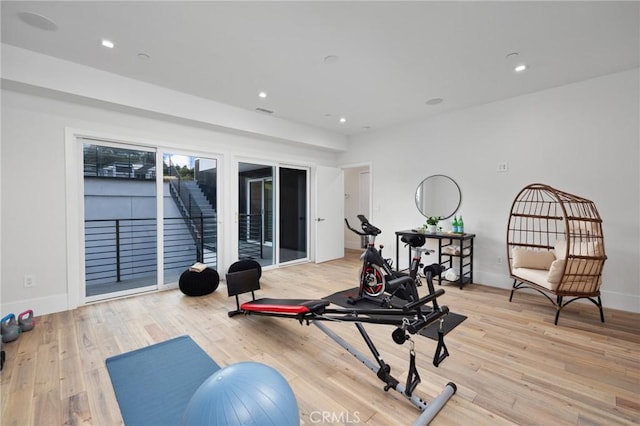 exercise room featuring baseboards, light wood finished floors, visible vents, and recessed lighting