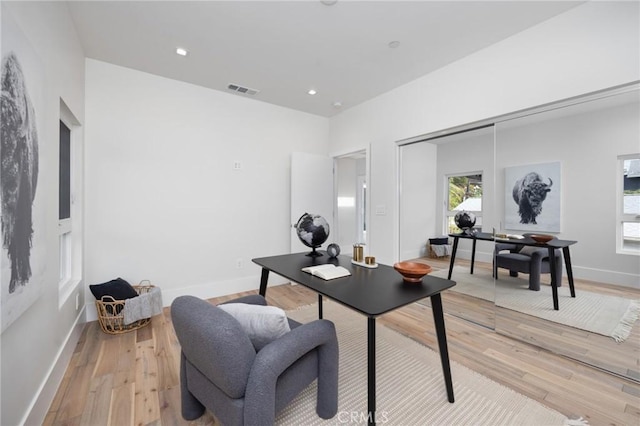 office space featuring light wood-type flooring, visible vents, baseboards, and recessed lighting