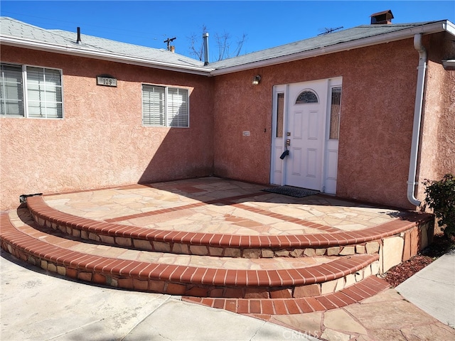 view of exterior entry with stucco siding