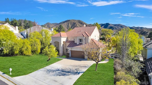 view of front of house featuring a tile roof, a mountain view, a front lawn, and stucco siding