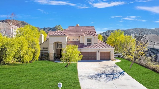 mediterranean / spanish-style home with stucco siding, a front yard, a mountain view, driveway, and a tiled roof