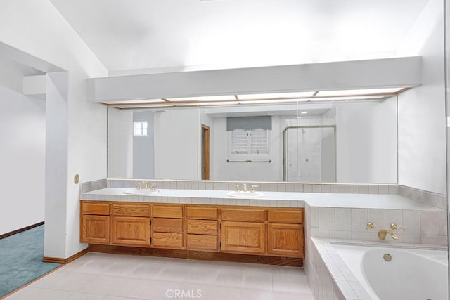 bathroom featuring a garden tub, double vanity, a stall shower, and a sink