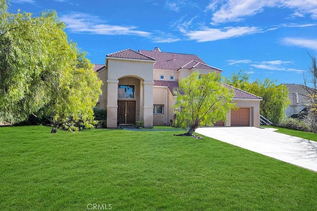 mediterranean / spanish home featuring stucco siding, a front yard, a garage, driveway, and a tiled roof