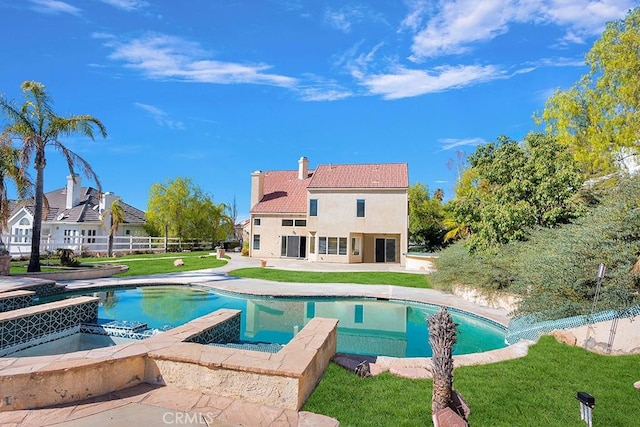 view of swimming pool with a pool with connected hot tub, a patio area, fence, and a lawn