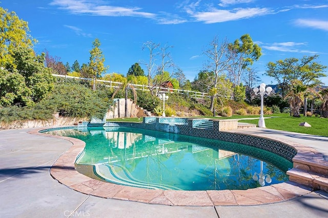 outdoor pool featuring fence and a lawn