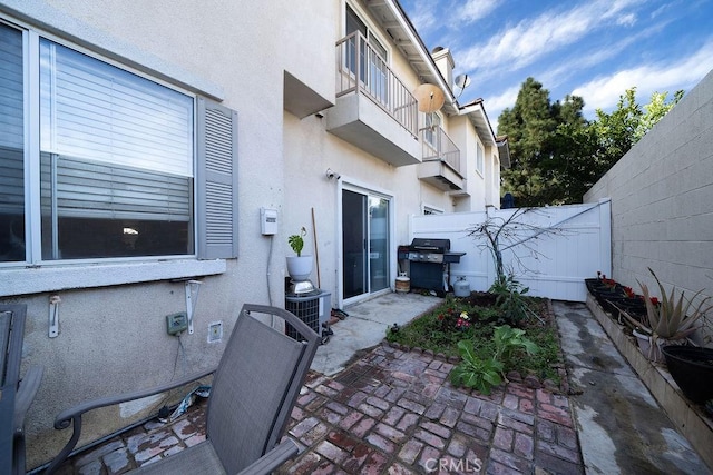 view of patio / terrace featuring central AC unit, a grill, and fence