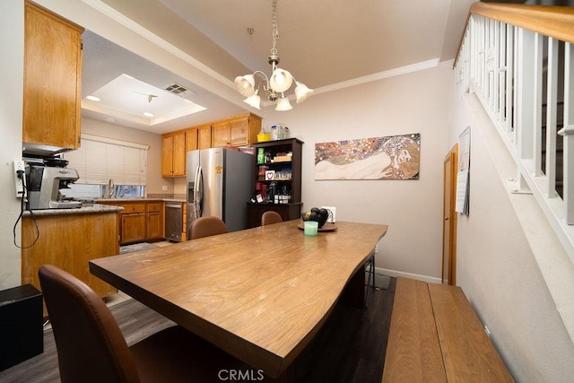 kitchen with visible vents, a raised ceiling, baseboards, appliances with stainless steel finishes, and a chandelier