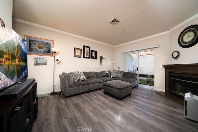 living area featuring dark wood-style flooring, visible vents, and crown molding