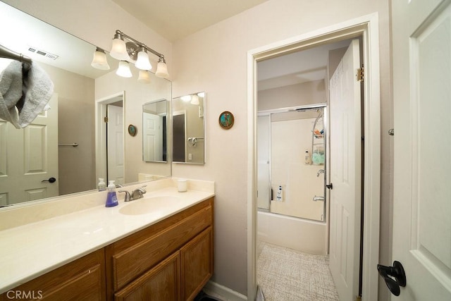 bathroom featuring shower / bath combination with glass door, visible vents, and vanity