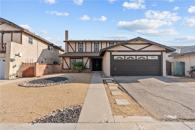 view of front of property with aphalt driveway, fence, an attached garage, and stucco siding