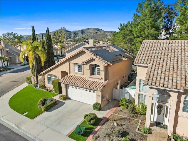 view of front of house featuring a garage, concrete driveway, a tiled roof, fence, and stucco siding