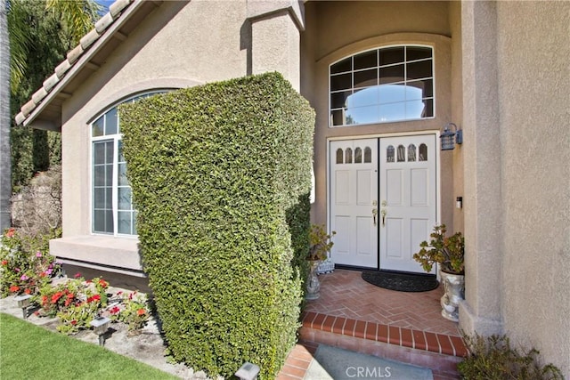 view of exterior entry featuring stucco siding