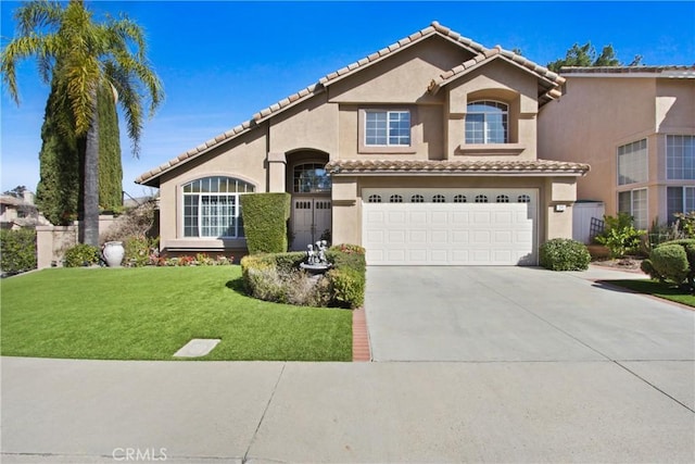 mediterranean / spanish-style house with a tile roof, stucco siding, a front yard, a garage, and driveway