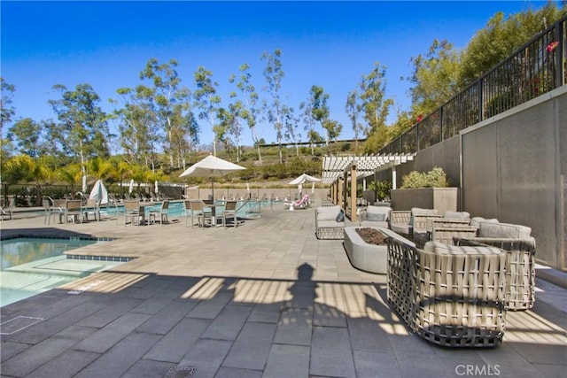 exterior space featuring an outdoor fire pit, fence, and a community pool