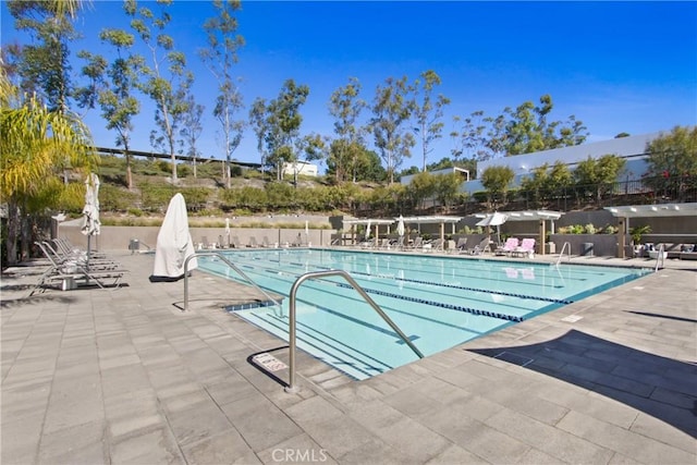 community pool featuring a patio and fence