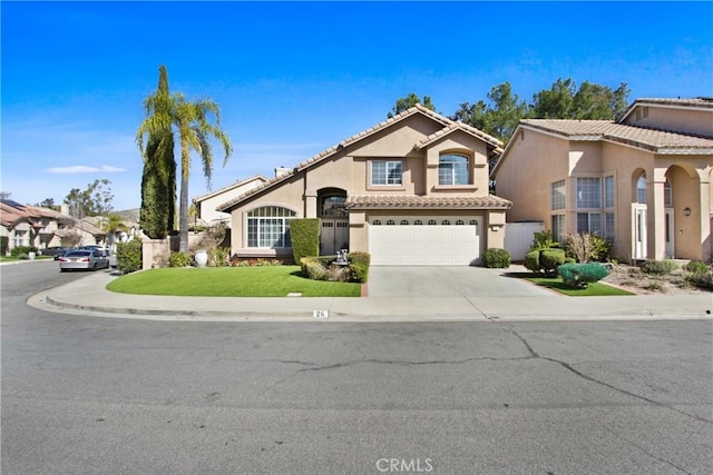 mediterranean / spanish-style home with a garage, concrete driveway, a tile roof, a front lawn, and stucco siding