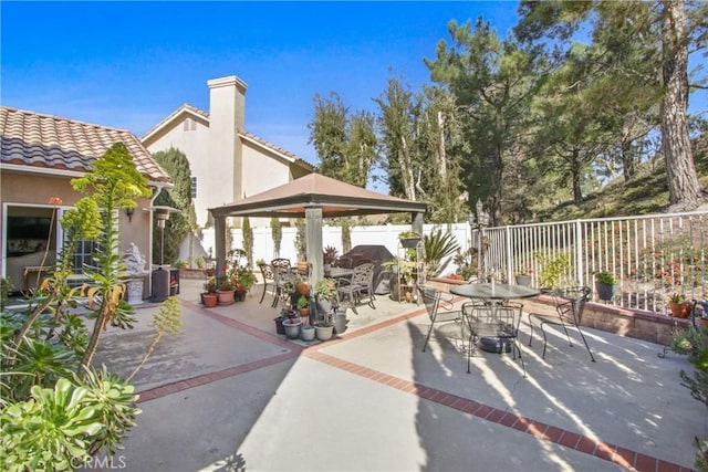 view of patio / terrace featuring a gazebo, fence, and outdoor dining space