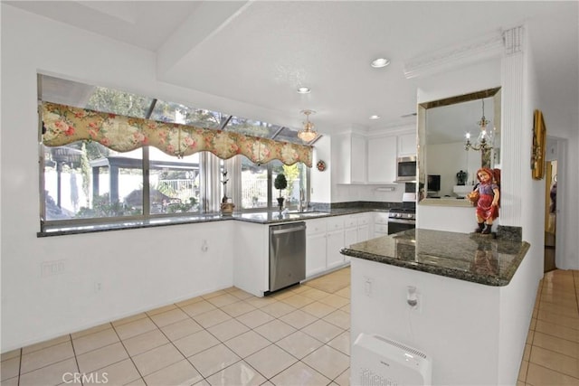 kitchen with light tile patterned floors, dark stone counters, a peninsula, stainless steel appliances, and white cabinetry