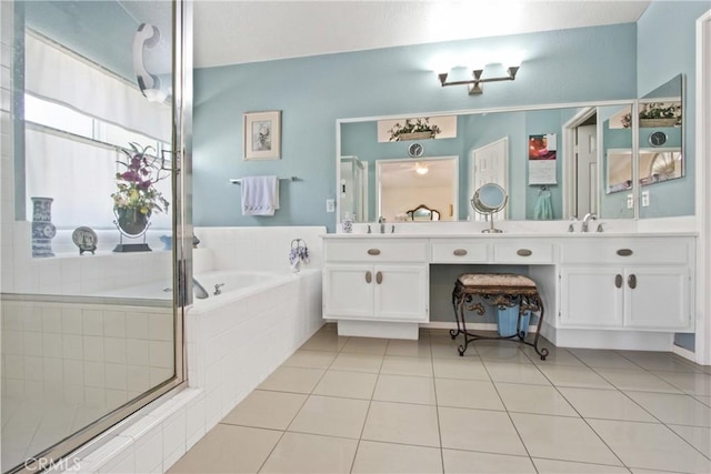 full bath featuring double vanity, tile patterned flooring, a sink, and a bath