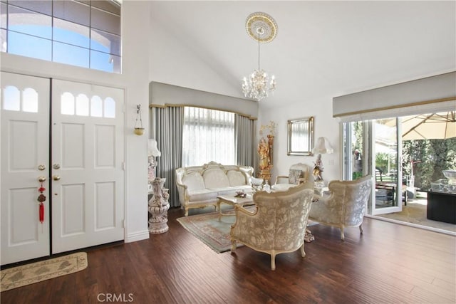 foyer entrance with high vaulted ceiling, wood finished floors, and a notable chandelier