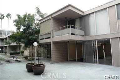 back of property featuring a balcony and a patio area