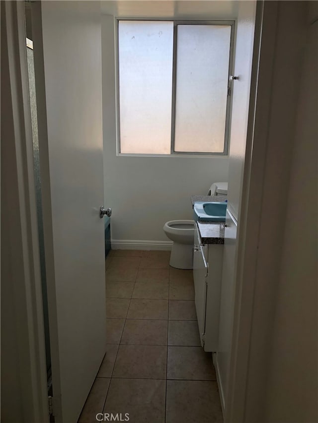 bathroom with baseboards, vanity, toilet, and tile patterned floors