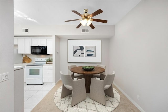 dining space featuring light tile patterned floors, ceiling fan, visible vents, and baseboards