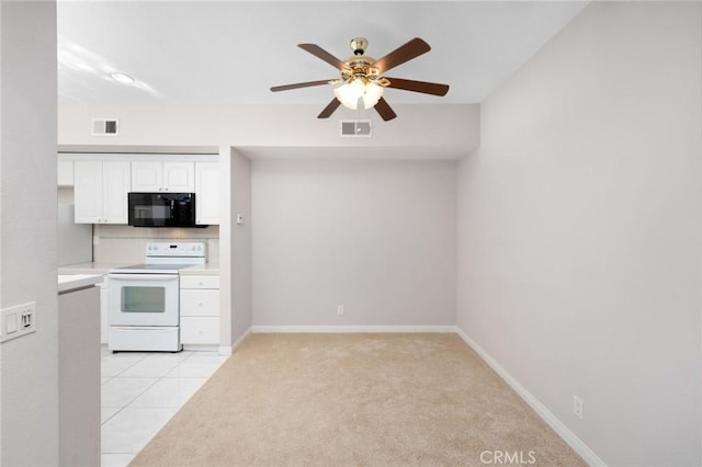 kitchen with white cabinetry, visible vents, black microwave, and electric stove