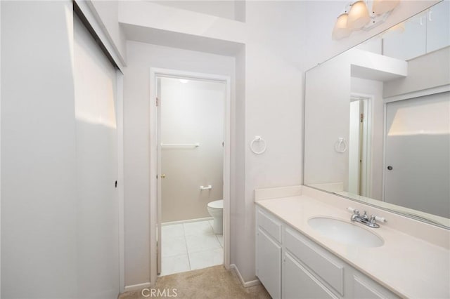 bathroom featuring baseboards, vanity, toilet, and tile patterned floors