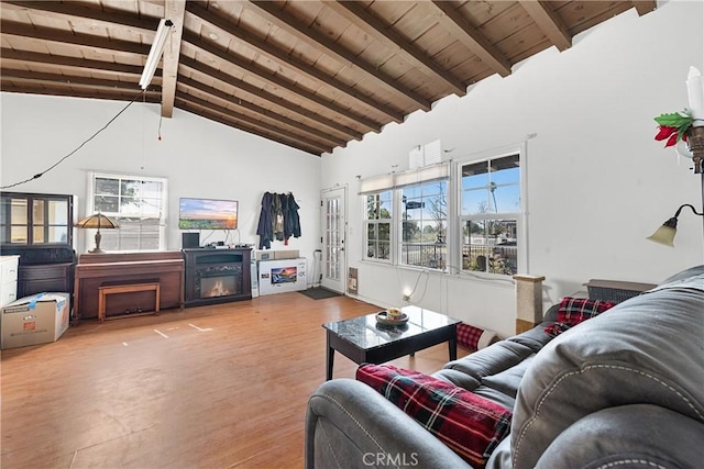 living area with wooden ceiling, a fireplace, vaulted ceiling with beams, and wood finished floors