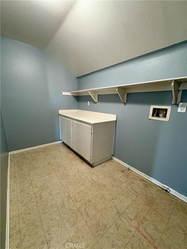 washroom featuring washer hookup, light floors, cabinet space, a textured ceiling, and baseboards