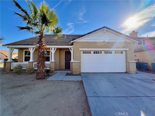 single story home featuring a garage, concrete driveway, a tiled roof, and stucco siding