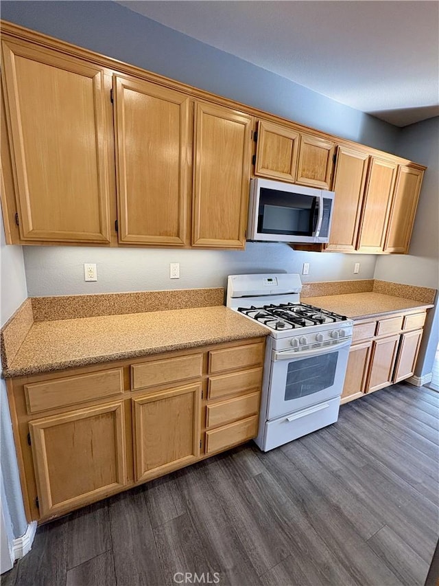 kitchen with light brown cabinetry, dark wood finished floors, and white gas range