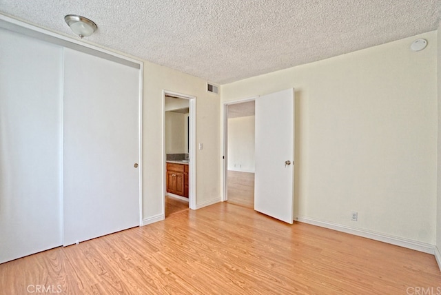 933 New Depot St Unit 6 & 7, Los Angeles, CA 90012 - unfurnished bedroom with a textured ceiling, light wood finished floors, and a closet