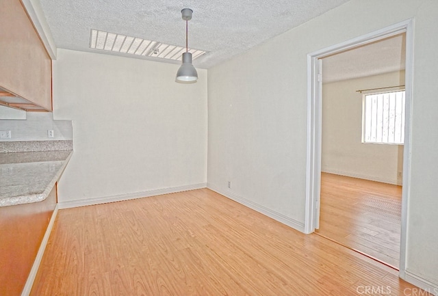 933 New Depot St Unit 6 & 7, Los Angeles, CA 90012 - unfurnished dining area featuring light wood-style floors and a textured ceiling