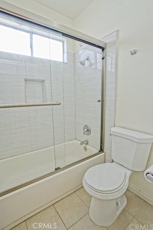 full bath featuring toilet, shower / bath combination with glass door, and tile patterned flooring