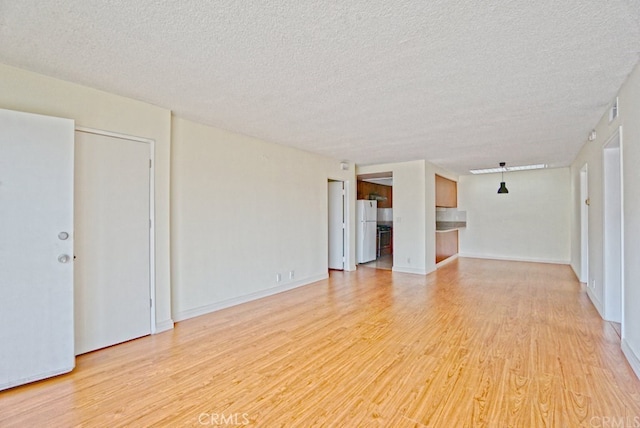 933 New Depot St Unit 6 & 7, Los Angeles, CA 90012 - unfurnished living room with light wood finished floors and a textured ceiling
