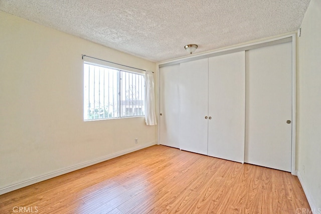 933 New Depot St Unit 6 & 7, Los Angeles, CA 90012 - unfurnished bedroom featuring light wood-type flooring, a textured ceiling, and a closet