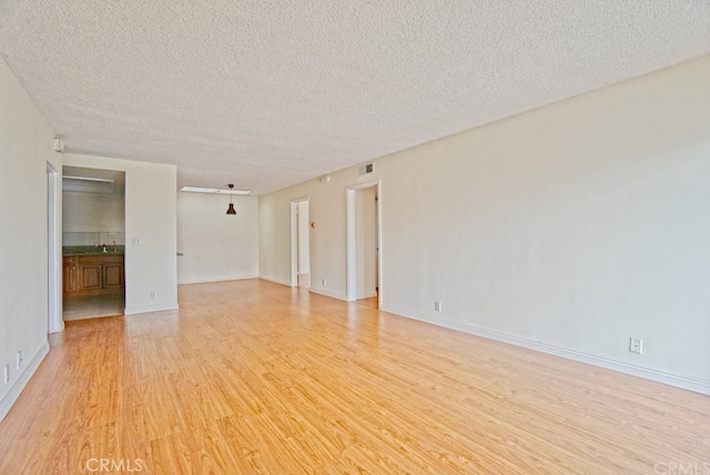 933 New Depot St Unit 6 & 7, Los Angeles, CA 90012 - empty room featuring light wood finished floors and a textured ceiling