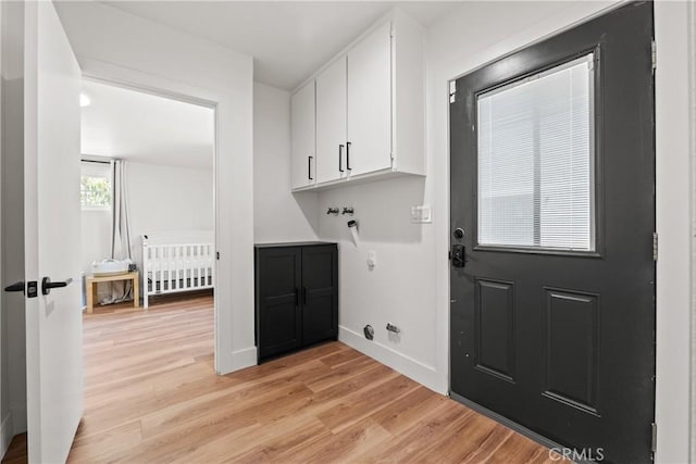 washroom featuring baseboards, cabinet space, and light wood finished floors