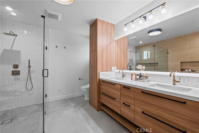 full bath featuring toilet, a shower stall, double vanity, and a sink