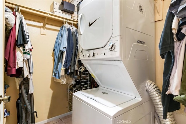 laundry room with laundry area, light tile patterned floors, and stacked washer and dryer